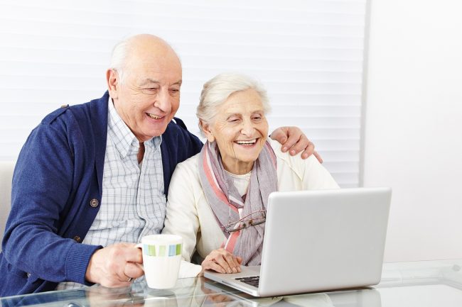 senior citizen couple using laptop computer