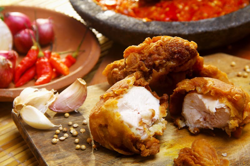 Delicious fried chicken served with fresh garlic and chili peppers. Perfect for a flavorful meal.