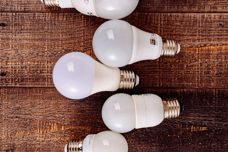 Collection of LED light bulbs arranged on a rustic wooden background. faulty lamp sockets