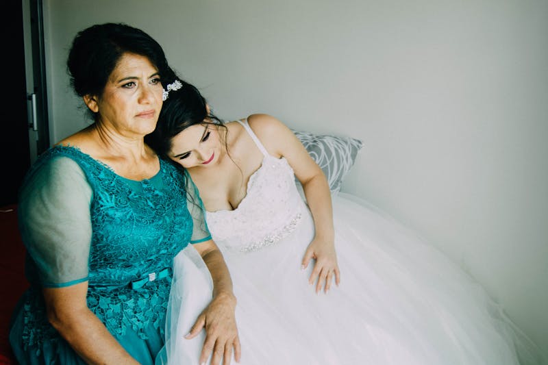 A bride shares a tender moment with her mother before the wedding ceremony.