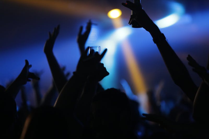 A lively nightclub scene with a crowd raising their hands, creating a vibrant nightlife atmosphere for a budget-friendly trip to Dubai.