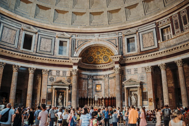 Interior view of the Pantheon in Rome filled with tourists capturing the grandeur of ancient architecture.