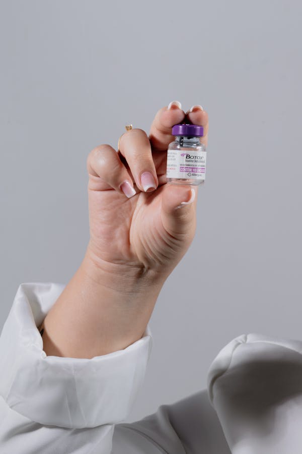 Close-up of a hand holding a Botox vial, ideal for healthcare stock images.