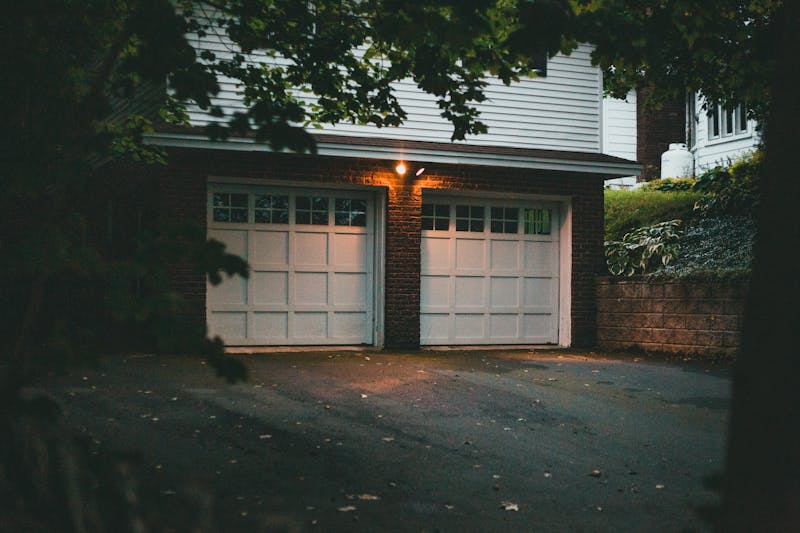 Warm evening view of a suburban garage with soft lighting creating a cozy atmosphere.