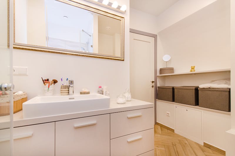 Stylish bathroom interior with sleek white vanity and large mirror.